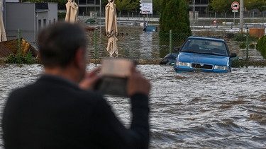 15.09.2024, Tschechien, Opava (Troppau): Ein Mann fotografiert eine überflutete Straße in der Nähe des Flusses Opava.  | Bild: dpa-Bildfunk/Ožana Jaroslav