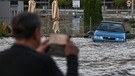 15.09.2024, Tschechien, Opava (Troppau): Ein Mann fotografiert eine überflutete Straße in der Nähe des Flusses Opava.  | Bild: dpa-Bildfunk/Ožana Jaroslav