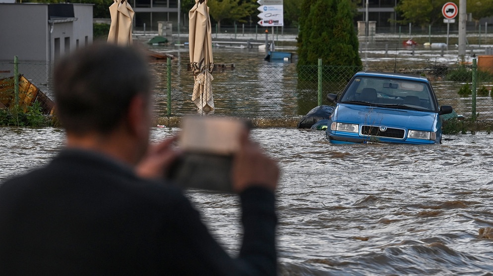 15.09.2024, Tschechien, Opava (Troppau): Ein Mann fotografiert eine überflutete Straße in der Nähe des Flusses Opava.  | Bild: dpa-Bildfunk/Ožana Jaroslav