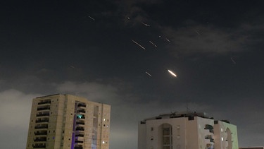 14.04.2024, Israel, Tel Aviv: Flammen von Explosionen erscheinen am Himmel über Tel Aviv, während Israels Raketenabwehrsystem Raketen und Drohnen aus dem Iran abfängt. Der Iran hat erstmals Israel direkt angegriffen. Trotz internationaler Warnungen schickte der Iran Drohnen und Raketen. | Bild: Tomer Neuberg/JINI/XinHua/+++ dpa-Bildfunk +++