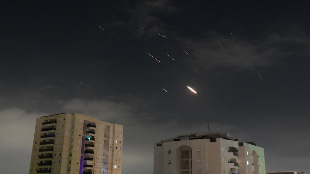 14.04.2024, Israel, Tel Aviv: Flammen von Explosionen erscheinen am Himmel über Tel Aviv, während Israels Raketenabwehrsystem Raketen und Drohnen aus dem Iran abfängt. Der Iran hat erstmals Israel direkt angegriffen. Trotz internationaler Warnungen schickte der Iran Drohnen und Raketen. | Bild: Tomer Neuberg/JINI/XinHua/+++ dpa-Bildfunk +++