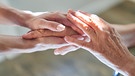 Hände liegen aufeinander, Symbolbild für Fürsorge | Bild:
stock.adobe.com/Robert Kneschke