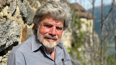 Der Bergsteiger Reinhold Messner sitzt auf einer Bank.  | Bild: dpa-Bildfunk/Christoph Sator