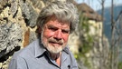 Der Bergsteiger Reinhold Messner sitzt auf einer Bank.  | Bild: dpa-Bildfunk/Christoph Sator