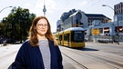 Leonie Schöler steht in Berlin. Im Hintergrund ist eine Trambahn zu sehen.  | Bild: Peter Rigaud