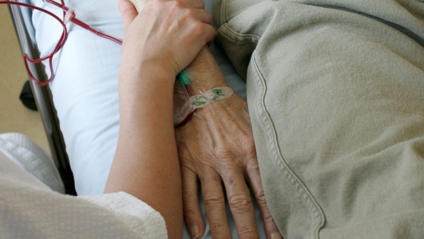 Die Palliativmedizin beinhaltet die Betreuung und Begleitung schwer kranker Menschen in ihrer letzten Lebensphase - im Bild: Hand halten am Krankenbett | Bild: picture-alliance/dpa