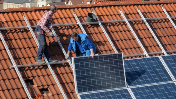 Arbeiter montieren Solarpanels | Bild: picture-alliance/dpa