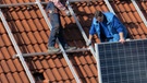 Arbeiter montieren Solarpanels | Bild: picture-alliance/dpa