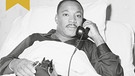 Martin Luther King wird in einem Krankenhausbett telefonisch über die Auszeichnung mit dem Friedensnobelpreis informiert | Bild: picture alliance / ASSOCIATED PRESS | Anonymous