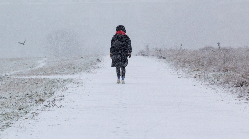 Symboldbild - eine Frau geht alleine einen verschneiten Weg entlang | Bild: picture alliance/dpa/dpa-Zentralbild | Hauke Schröder