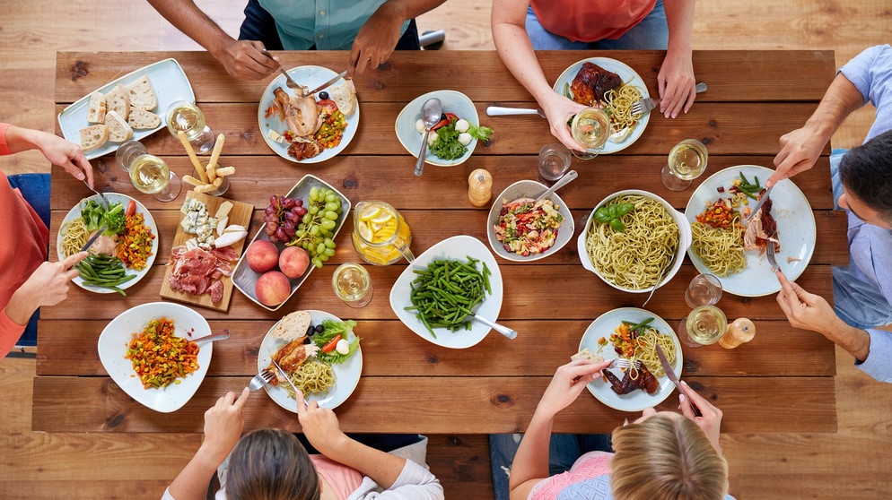 Familie am Essenstisch von oben. Das gemeinsame Essen ist wie das Lagerfeuer, um das sich unsere Urahnen versammelten. Beim Essen werden Geschichten erzählt, Verträge besiegelt, Kinder erzogen, Taufen, Hochzeiten und Beerdigungen gefeiert.  | Bild: colourbox.com