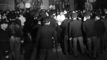 Polizisten gehen am 22.06.1962 in München-Schwabing gegen eine aufgebrachte Menschenmenge meist jugendlicher Protestierender vor. Bei den Krawallen kam es immer wieder zu Straßenschlachten. | Bild: picture-alliance/dpa