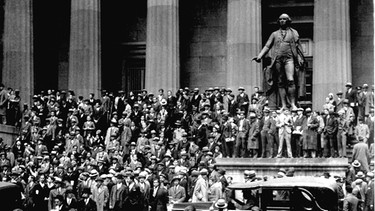 Menschen versammeln sich am „Schwarzen Donnerstag“, dem 24. Oktober 1929, auf den Stufen des Sub-Treasury-Gebäudes gegenüber der New Yorker Börse in New York. | Bild: picture alliance / ASSOCIATED PRESS