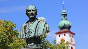 Denkmal von Johann Andreas Schmeller vor der Stadtpfarrkirche Mariä Himmelfahrt, Tirschenreuth, Oberpfalz, Bayern, Deutschland | Bild: picture alliance / imageBROKER | BAO