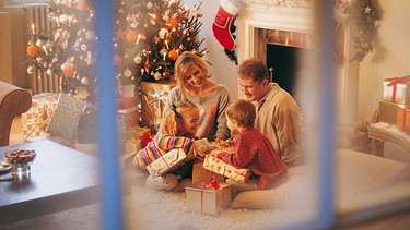 Symbolbild: Familie am Weihnachtsabend in ihrem Wohnzimmer | Bild: Digital Vision