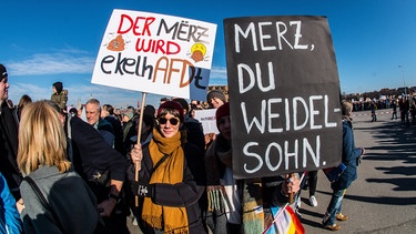 Auf zwei Demoplakaten ist zu lesen "Der März wird ekelhADFt" und "Merz, du Weidel Sohn"  | Bild: picture alliance / ZUMAPRESS.com | Sachelle Babbar