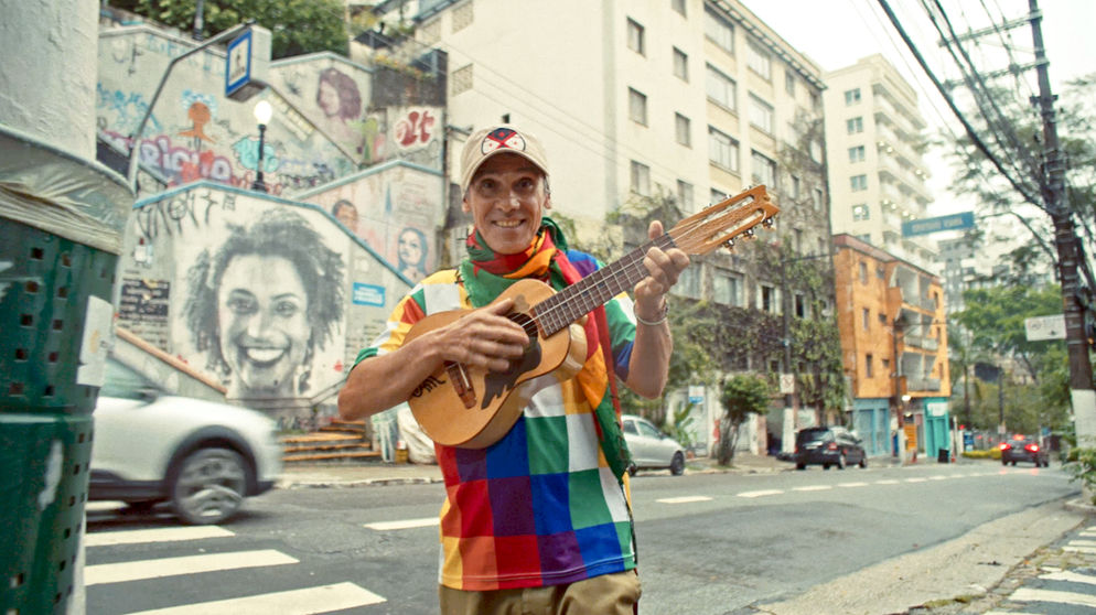 Manu Chao steht mit einer Gitarre auf der Straße | Bild: Sofia Dowbor