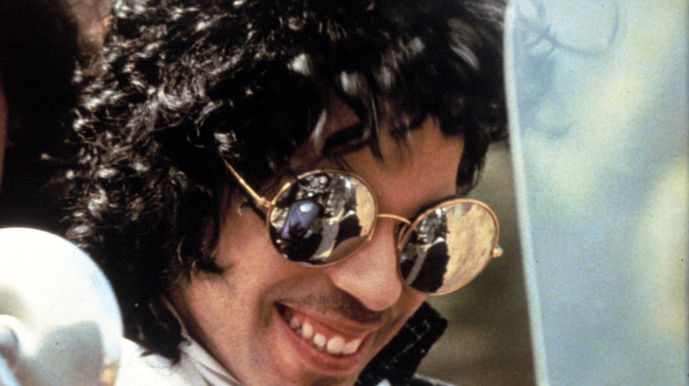 Prince trägt Sonnenbrille und lacht | Bild: Everett Collection/picture alliance