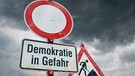 Schilder mit der Aufschrift: "Demokratie in Gefahr"  | Bild: picture alliance / SULUPRESS.DE | Torsten Sukrow / SULUPRESS.DE