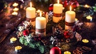 Ein Adventskranz mit vier brennenden Kerzen. | Bild: stock.adobe.com