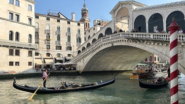 Eine Gondel mit Touristen vor der Rialto-Brücke im Zentrum von Venedig. | Bild: dpa-Bildfunk/Christoph Sator