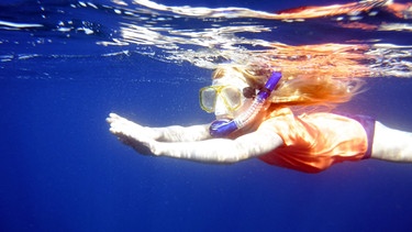 Ein Kind schwimmt und taucht im Meer. | Bild: BR/Sandra Vogell