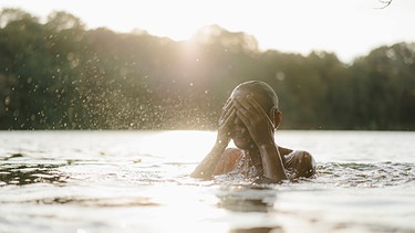 Symbolbild "Belebendes Wasser" - Frau erfrischt sich im See  | Bild: picture alliance_Westend61_Kniel Synnatzschke
