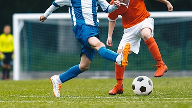 Symbolbild Fußball_Zwei jugendliche Fußballspieler in einem Zweikampf um den Ball  | Bild: stock.adobe.com_matimix