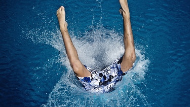 Kind springt im Freibad kopfüber ins Wasser | Bild: picture-alliance/dpa
