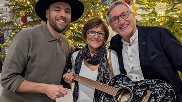 Sänger Max Mutzke übergibt die BR Schlager-Gitarre an den Meistbietenden Werner Schoppmeier | Bild: BR-Harry Blaha