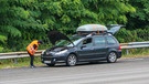 Auto mit Panne steht am Straßenrand. Kofferraum und Motorhaube stehen offen. Insasse wirft einen Blick in den Motorraum. | Bild: picture alliance / Hans Lucas | Nicolas Guyonnet