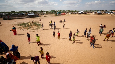 Symbolbild: Somalische Flüchtlingskinder spielen am Donnerstag, 13. Juli 2023, draußen auf einem offenen Feld im Flüchtlingslager Dadaab im Norden Kenias. | Bild: picture alliance / ASSOCIATED PRESS | Brian Inganga