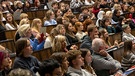 Studierende nehmen an der Einführungsveranstaltung im Audimax der Ludwig-Maximilians-Universität (LMU) teil. | Bild: picture alliance/dpa | Peter Kneffel