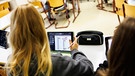 Schülerinnen einer sechsten Klasse arbeiten in ihrem Klassenraum während einer Unterrichtsstunde an ihren Tablets.  | Bild: picture alliance / dpa | Matthias Balk