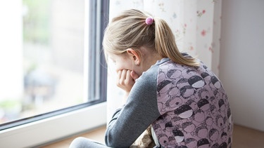 Ein Kind schaut während der Corona-Pandemie aus einem Fenster | Bild: picture alliance / Fotostand | Fotostand / K. Schmitt