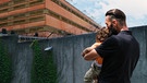 Ein Manns teht mit Kind vor einem Gefängnis.  | Bild: BR 