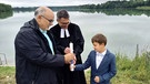 Pfarrer Siegfried Martin mit Täufling Paul und Vater Jürgen Bernert | Bild: BR/Iris Tsakiridis