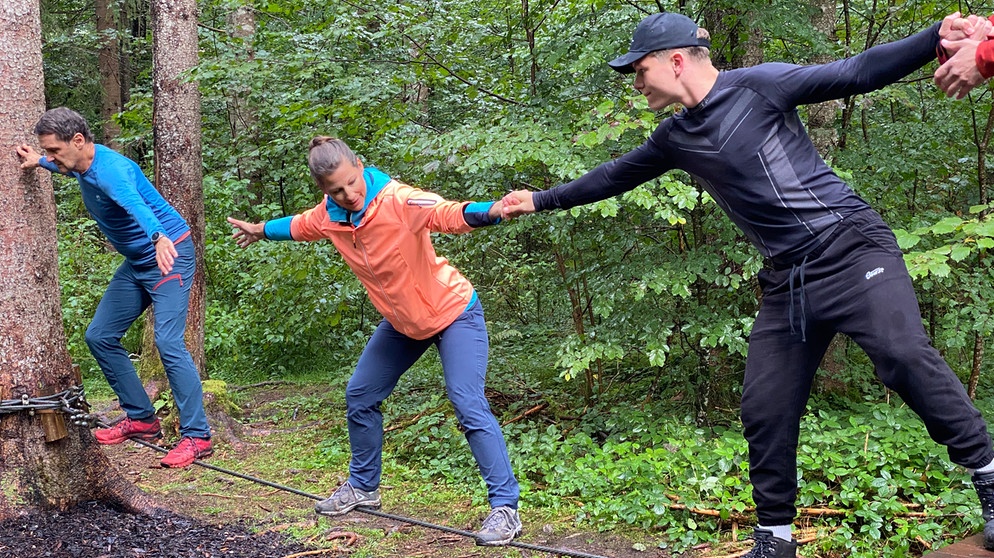 In einem Niedrigseilgarten in Fall bei Lenggries nimmt STATIONEN-Moderatorin Irene Esmann (M.) an einem Seminar teil, mit dem Gruppen lernen sollen, sich gegenseitig zu vertrauen. | Bild: BR/ Christian Wölfel 