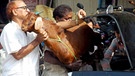 Islamisches Opferfest: Inder versuchen, Ziege in ein Taxi zu verladen. | Bild: picture-alliance/dpa