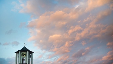 Ein Kirchturm in Abendrot getaucht  | Bild: picture-alliance/dpa