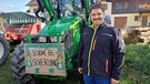 Sebastian Roß mit seinem Traktor und einem Demo-Schild | Bild: Iris Tsakiridis