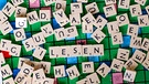 Scrabble-Buchstaben bilden "Lesen". Rund 765 Millionen Menschen weltweit sind Analphabeten. In Deutschland können über sechs Millionen Erwachsene nicht richtig lesen und schreiben. | Bild: picture-alliance/dpa