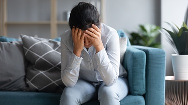 Frau hält ihren Kopf, ist erschöpft, kraftlos, Kopfschmerzen. Chronic Fatigue Syndrom kann eine Langzeitfolge von Covid-19 sein. | Bild: colourbox.com