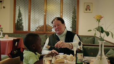 Café Waldluft: Flora Kurz "Mama Flora" und Juma Kayaga beim Weißwurst essen.  | Bild: BR