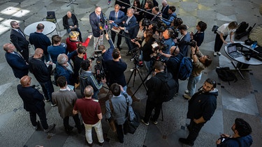 Nach dem Urteil des OVG Münster äußern sich Roman Reusch (M.l.), Beisitzer im Bundesvorstand der AfD, und Peter Boehringer (r. daneben), stellvertretender Bundessprecher der AfD, in der Gerichtslobby vor Journalisten.  | Bild: picture-alliance/dpa | Guido Kirchner