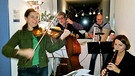 Das legendäre "LuL-Quartett" spielt bei der Weihnachtsfeier der Redaktion "Land und Leute": Traudi Siferlinger an der Geige, Paul am Kontrabass, Roland Köhler am Akkordeon und Eva Mayer bläst in die Flöte. Paul hat auch als Jazz-Bassist sein Geld verdient und spielt Klavier und Orgel.  | Bild: privat