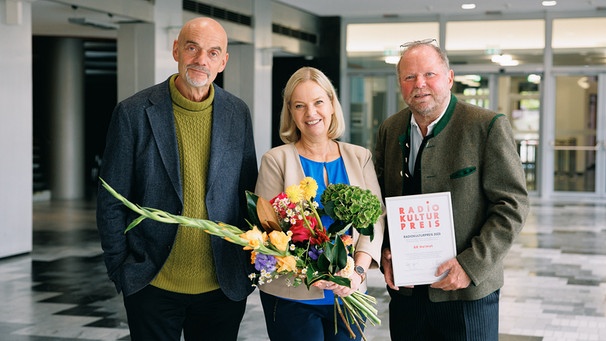 Ralf Weigand, Aufsichtsratsvorsitzender der GEMA, überreichte den Preis im Münchner BR-Funkhaus an Iris Mayerhofer, BR-Programmbereichsleiterin Unterhaltung und Heimat, und Stefan Frühbeis, Redaktionsleiter BR Heimat | Bild: BR